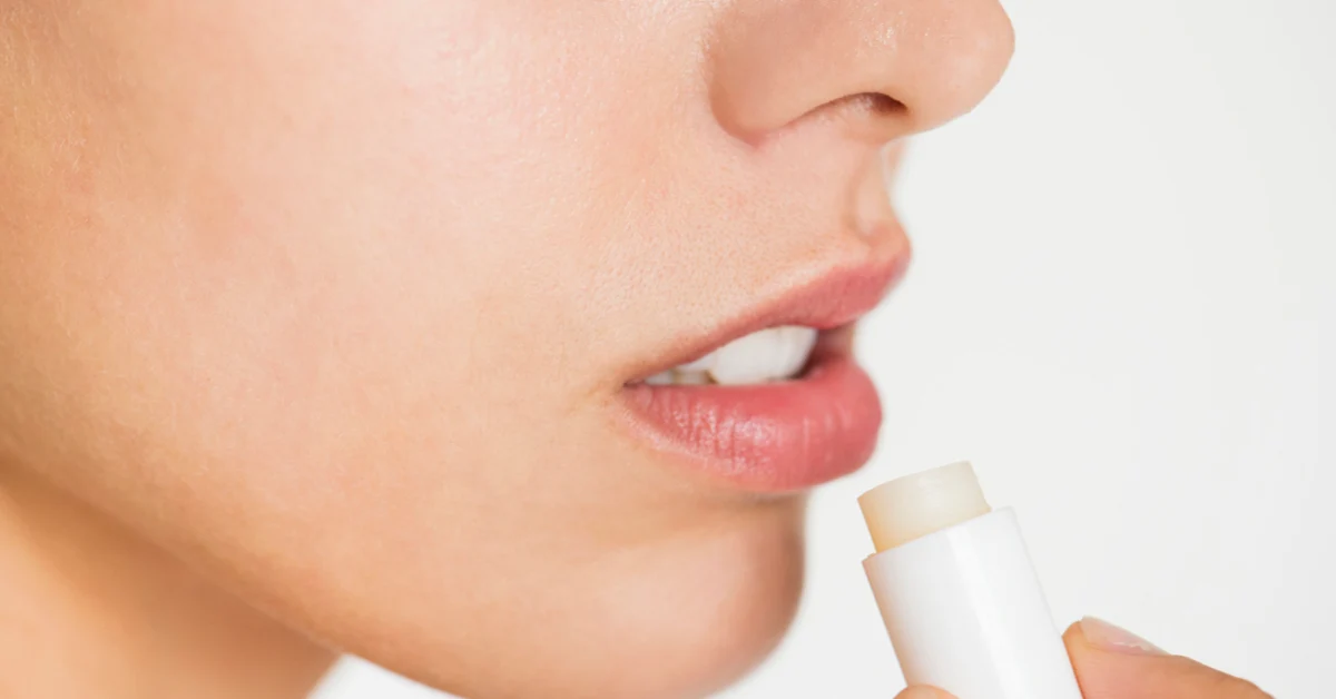 Woman gently applying lip balm during her daily skincare routine